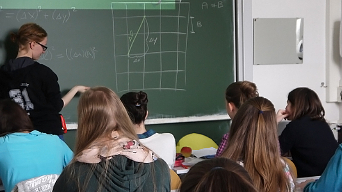 Foto: Schülerin berechnet Aufgabe an der Tafel