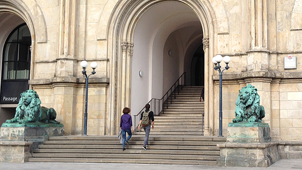 Zwei Studierende betreten das Hauptgebäuder der Leibniz Universität Hannover