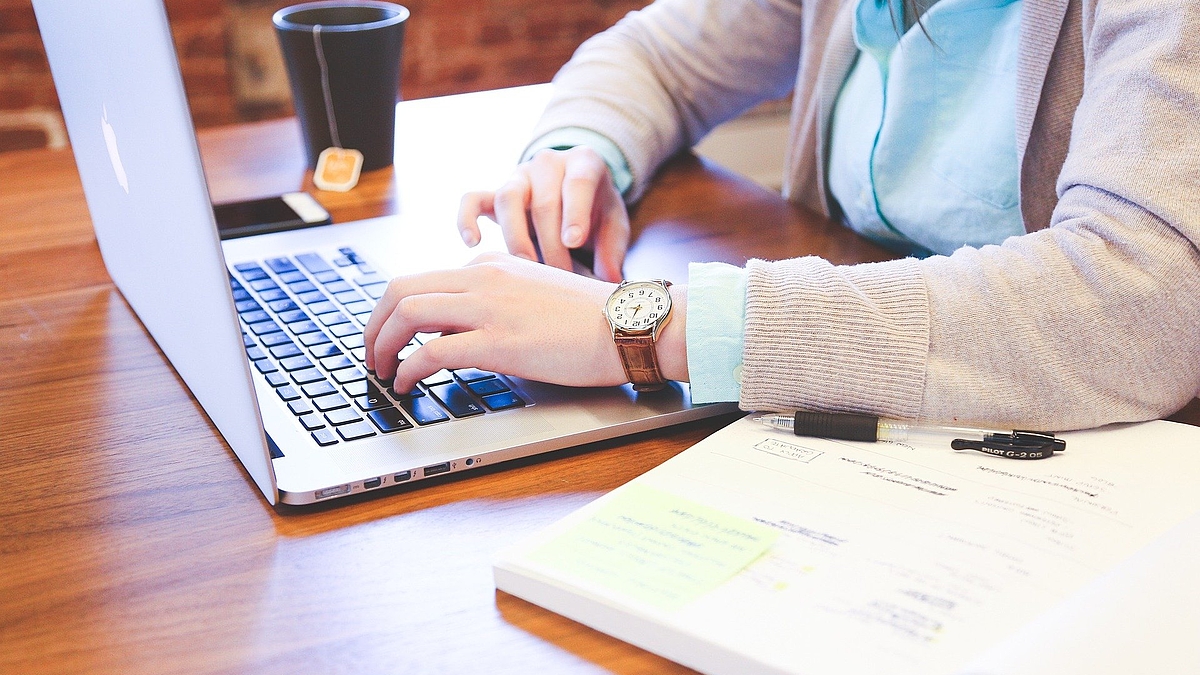 Foto: Recherchieren am Schreibtisch mit Laptop